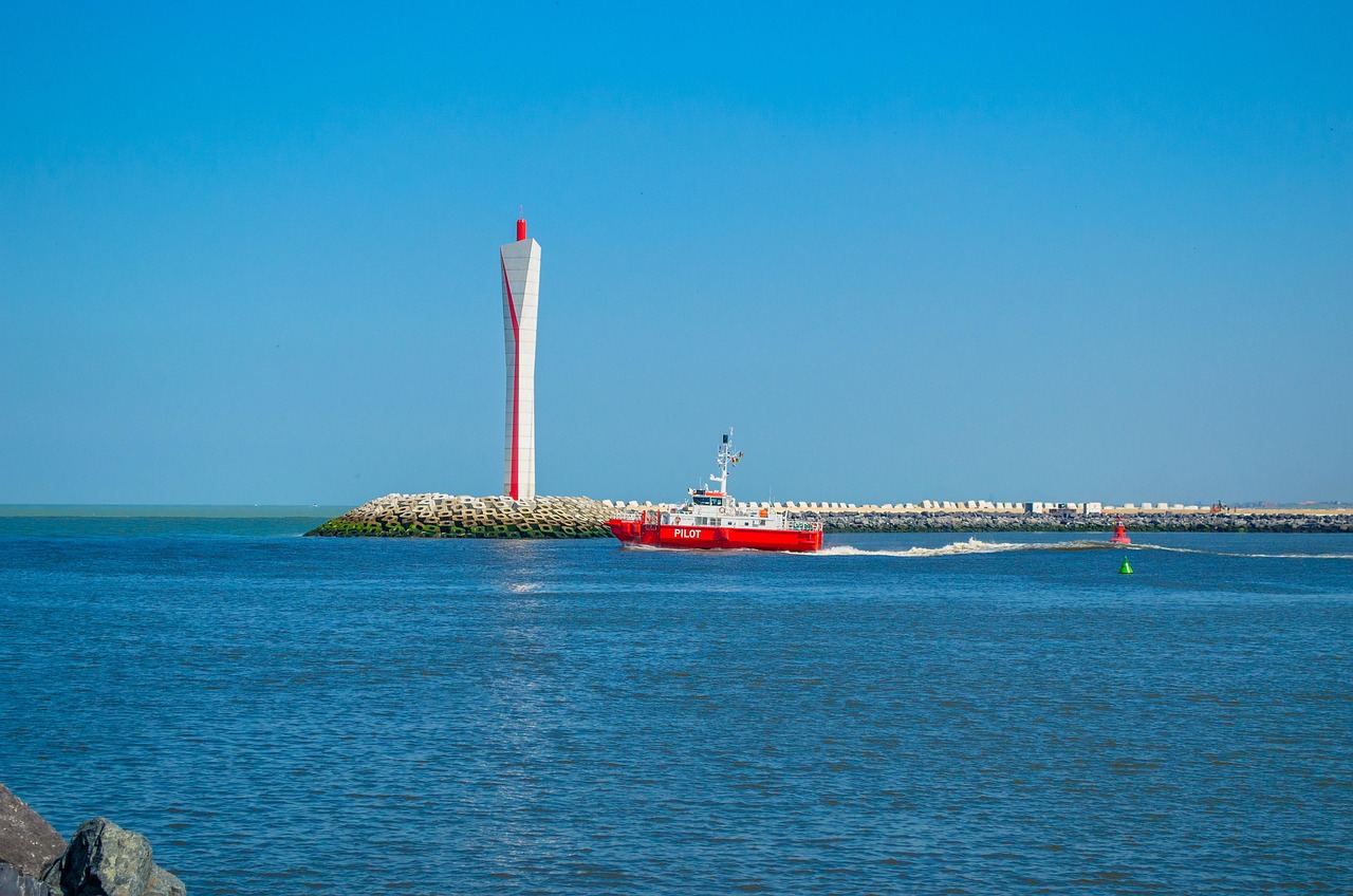 In this image, a vessel is depicted on the water's surface. The background encompasses a tower, buildings, and the expanse of the sky.\n
