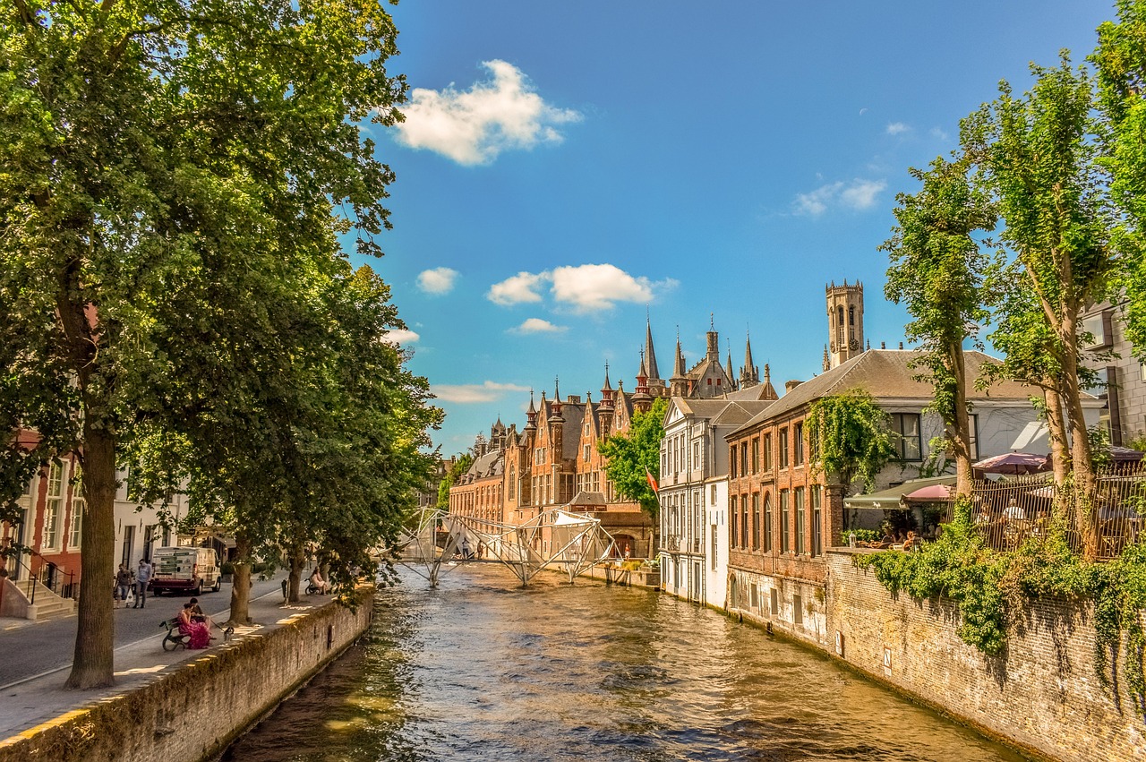 In this image, a diverse array of objects is depicted, including water, trees, buildings, tents, people, vehicles, and other unidentified entities. The background of the image is characterized by a sky.\n
