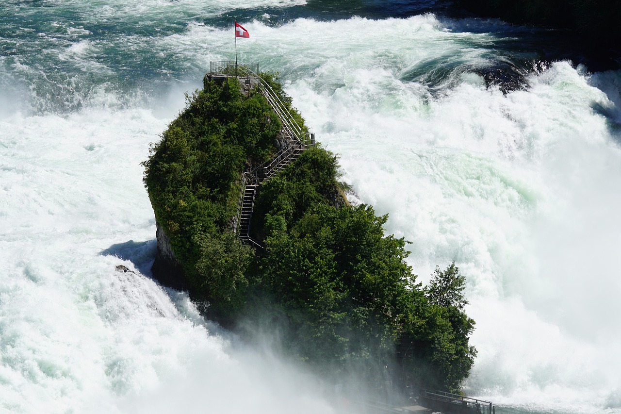 In the provided image, a flag is prominently displayed on a hilltop. The background of the image consists of a body of water.\n
